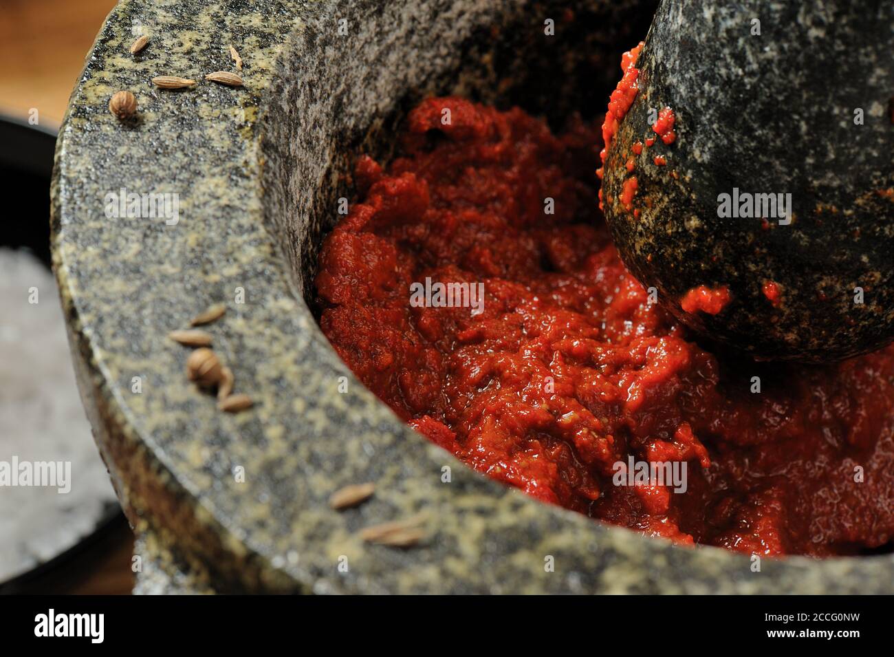 Harissa chili paste in a mortar with pestle Stock Photo