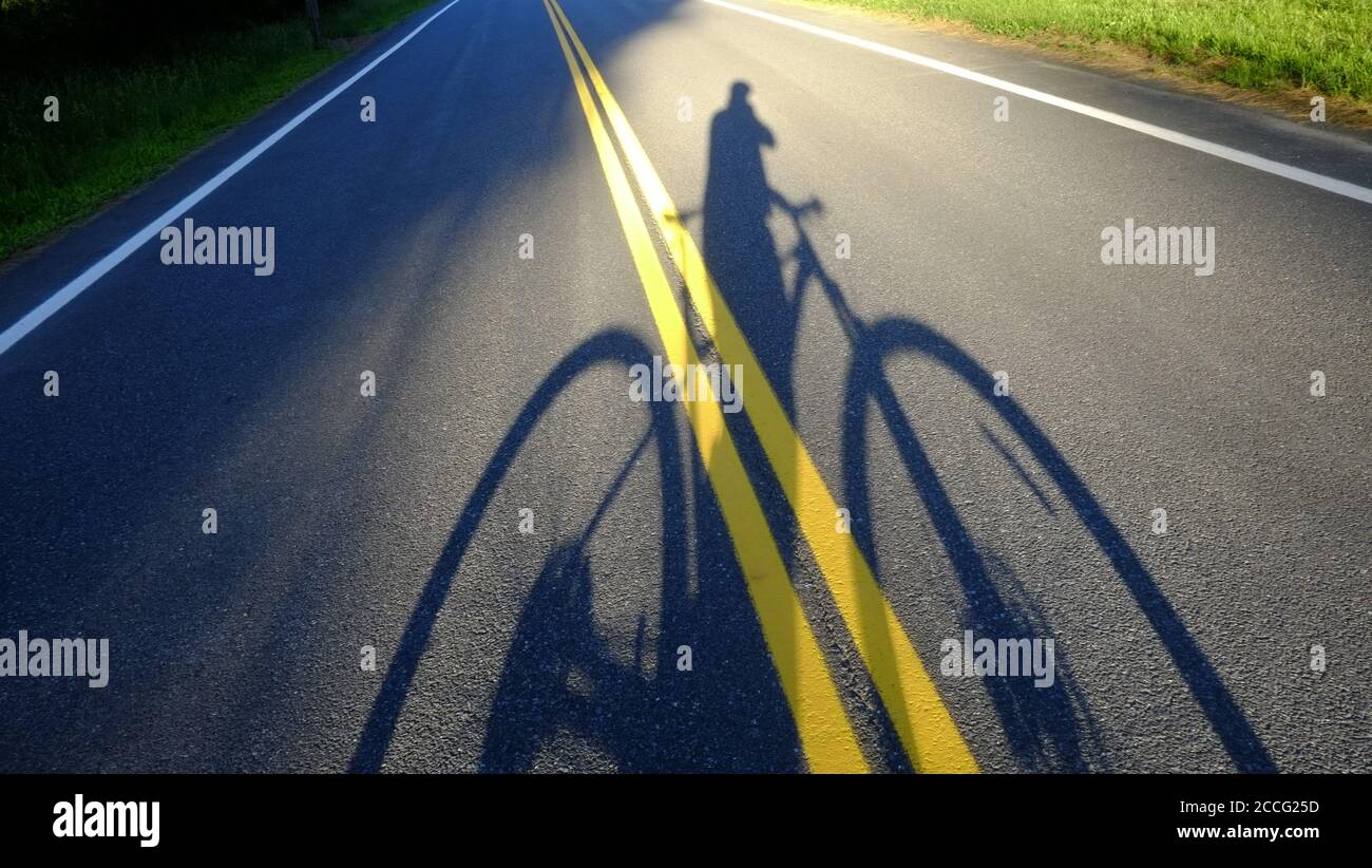 Cyclist's shadow projected or road, Lake Hill, NY Stock Photo
