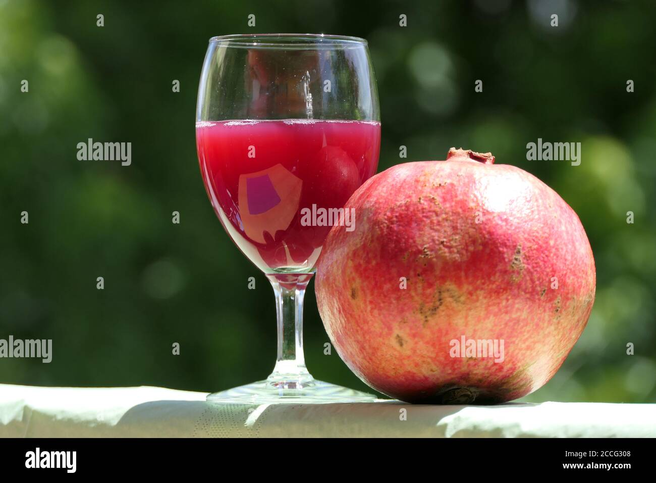 Pure health: freshly squeezed pomegranate juice in a glass with a whole ripe pomegranate fruit Stock Photo