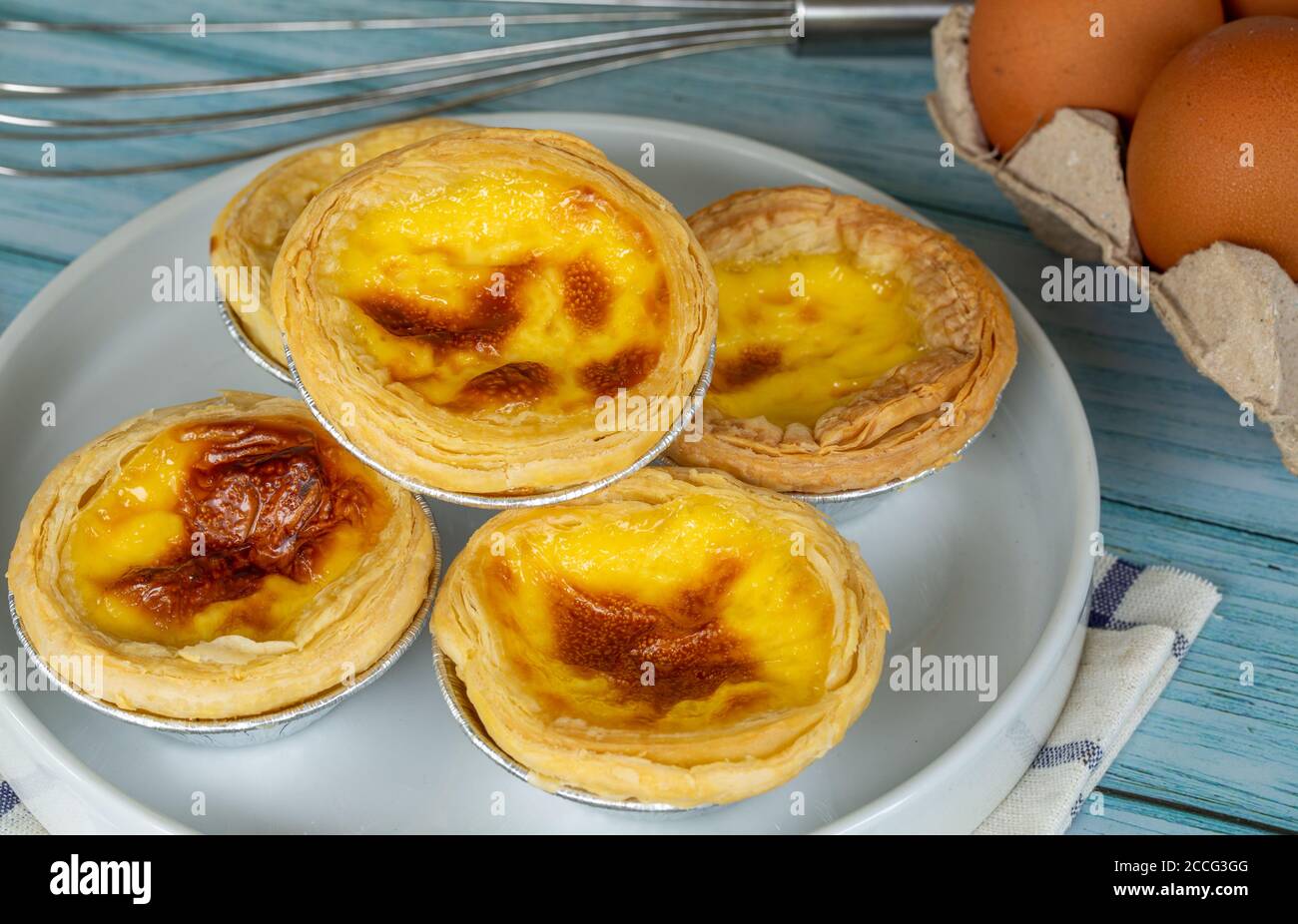 Homemade egg tart or portugal egg tart sweet custard cream on white dish with eggs ingredients, close-up Stock Photo
