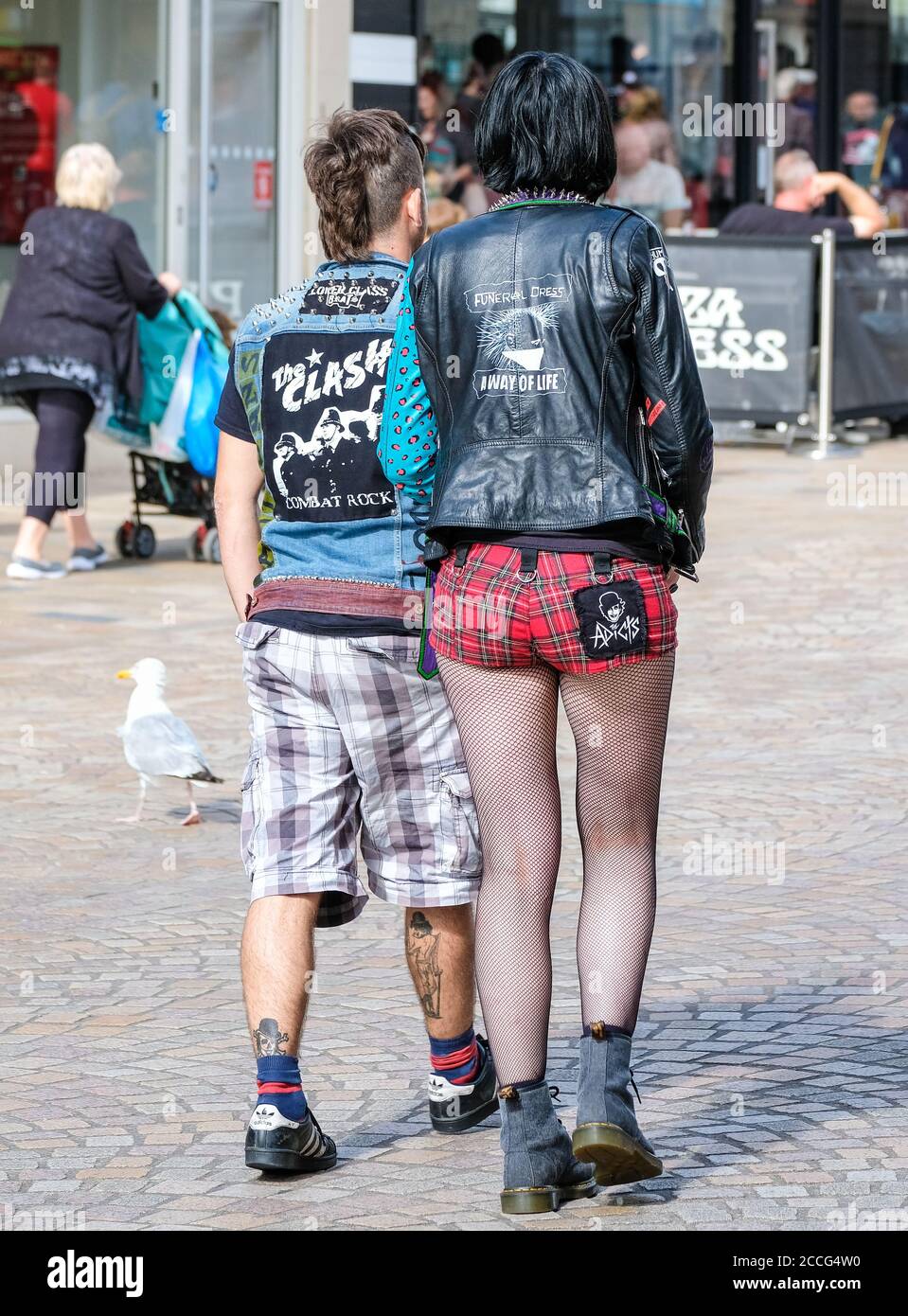 young punk couple, he with long shorts and she with check hot-pants Stock Photo