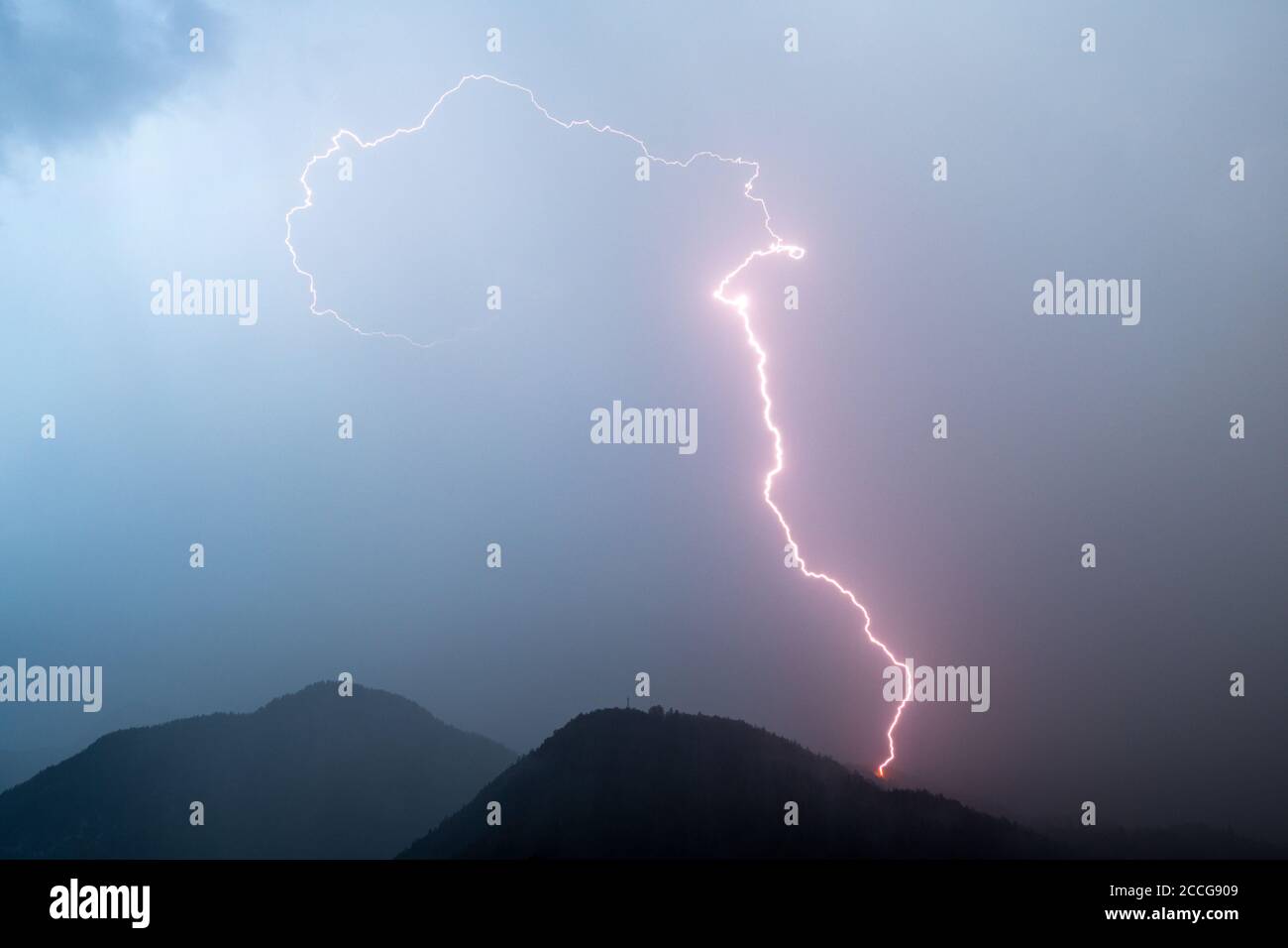 Lightning strike during a strong summer thunderstorm in the Wildsteinkopf near Mittenwald in the Bavarian Alps, with the Wetterstein in the background Stock Photo