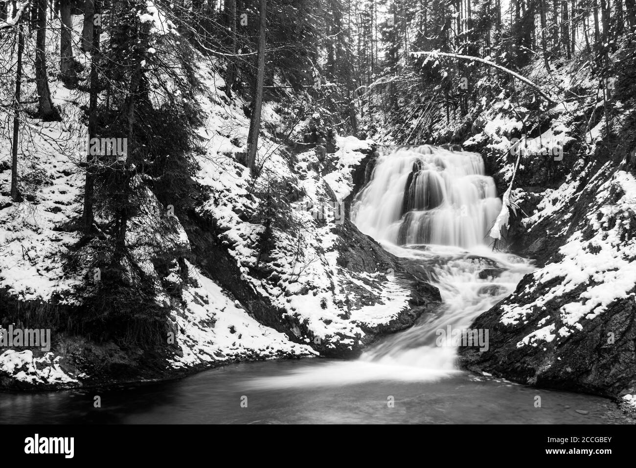 Waterfall of the Obernach Canal between Wallgau and the Walchensee in the Bavarian Prealps in winter with snow Stock Photo