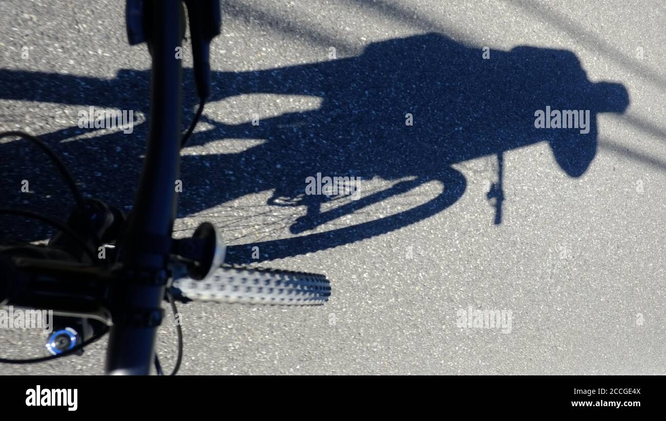 Cyclist's shadow projected or road, Lake Hill, NY Stock Photo