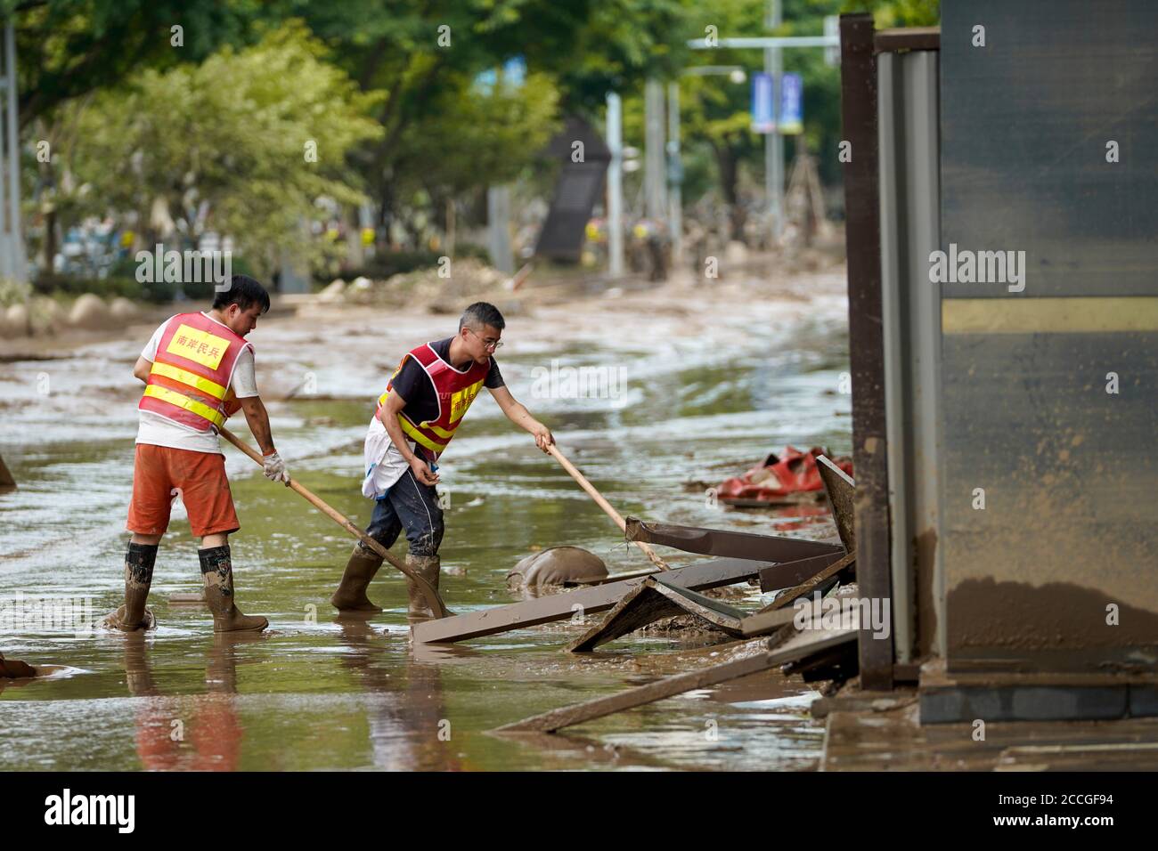 Chongqing. 22nd Aug, 2020. People clean out a road in southwest China's Chongqing Municipality, Aug. 22, 2020. Floodwater in southwest China's Chongqing Municipality started receding as the water level at the Cuntan hydrologic station fell below the alarm level of 180.5 meters at 8 a.m. Saturday. Disaster relief and production resumption are underway. Credit: Liu Chan/Xinhua/Alamy Live News Stock Photo