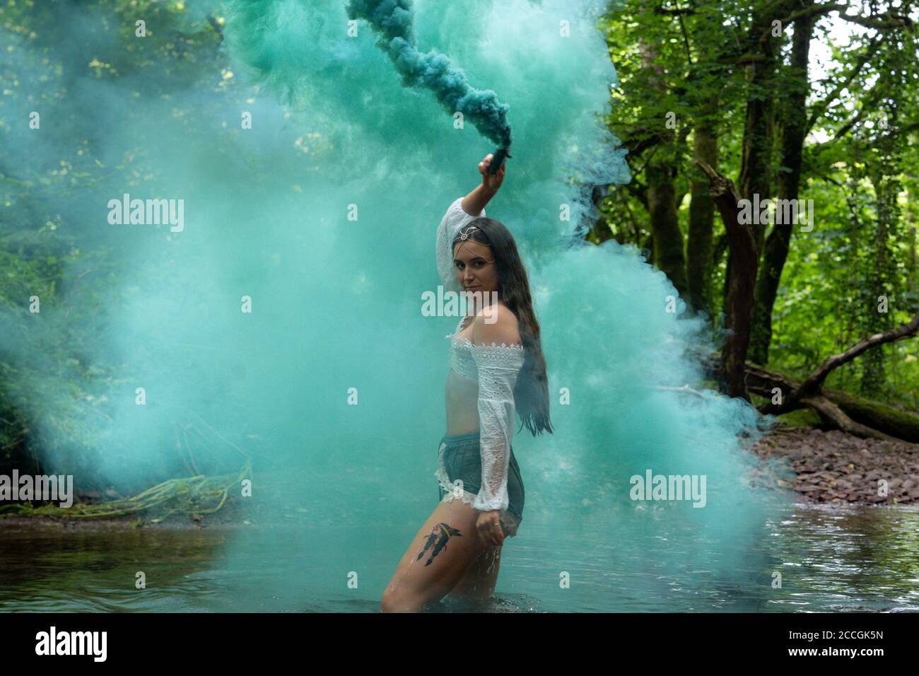 Irish girl using smoke bomb in a forest Stock Photo Alamy