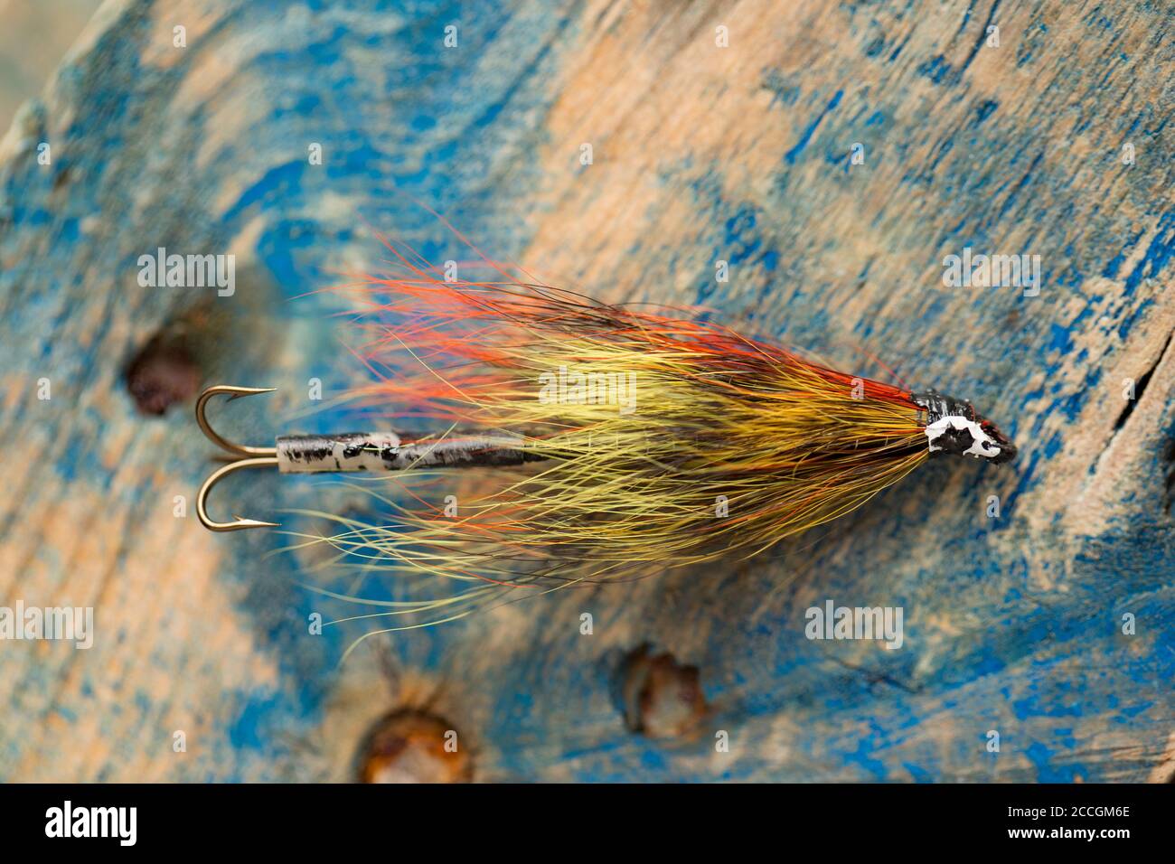 An old salmon fly equipped with a treble hook taken from a fly box, or  reservoir. Displayed on a piece of driftwood. From a collection of fishing  tac Stock Photo - Alamy