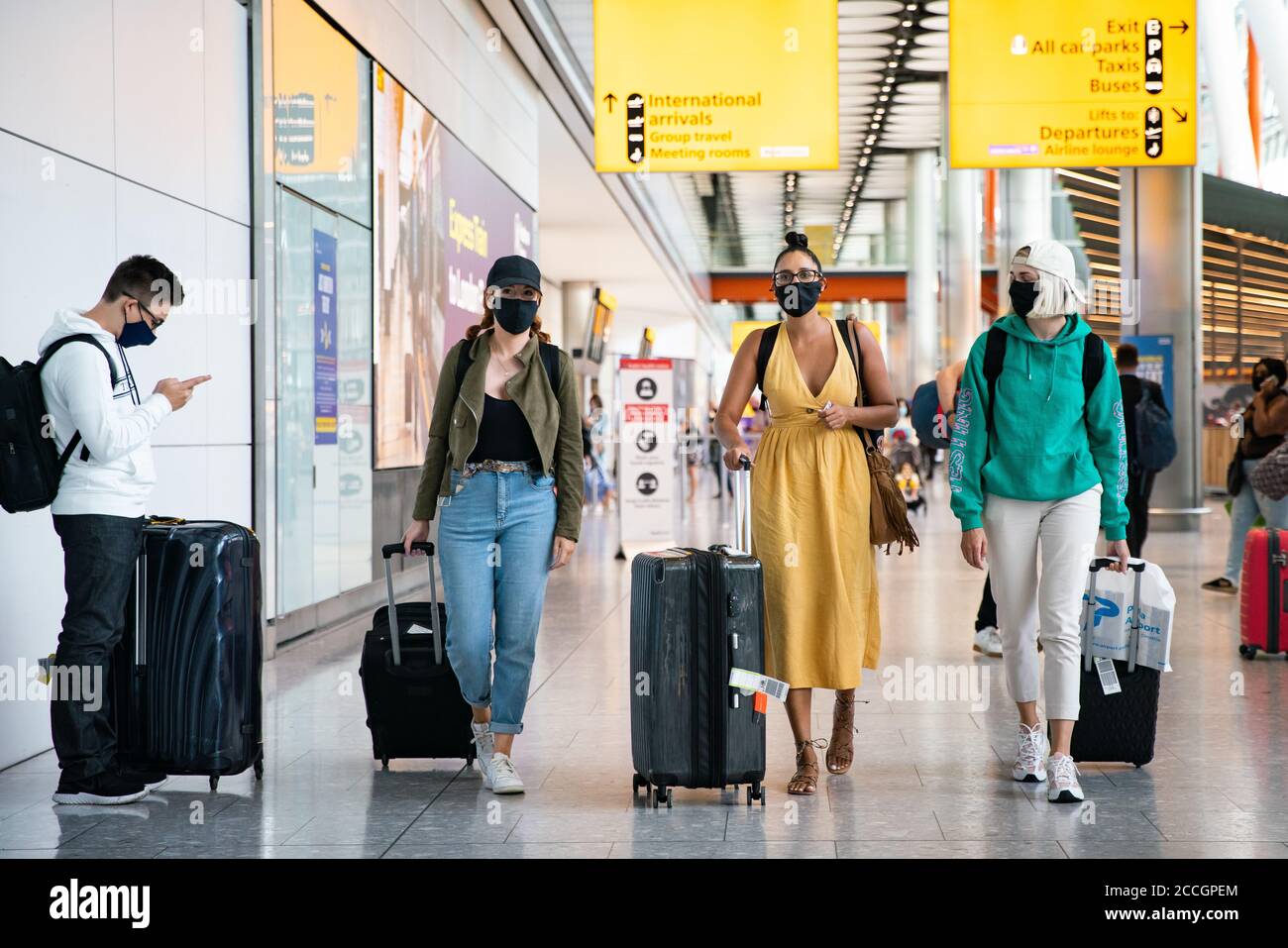 (left to right) Alex Parr, Carmen Jones and Neringa Juskauskaite who have arrived in from Pula, Croatia to London Heathrow Airport and now how to self isolate for 14 days. Stock Photo