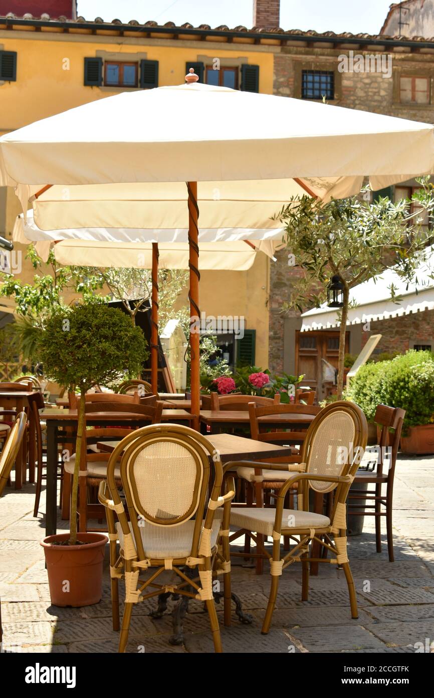 Extra binnenvallen molen Pretty deserted cafe table and chairs with white parasol in, Montecatini  Alto, Italian street Stock Photo - Alamy