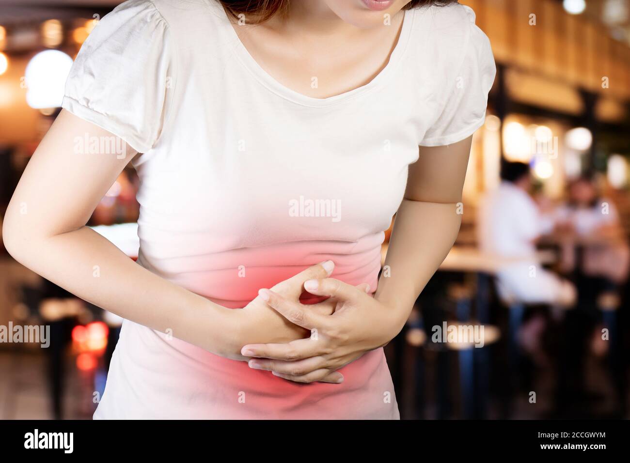 Woman suffer from stomachache or Gastroenterologist. Concept with Healthcare And Medicine. Pain in red color. Isolate with clipping path on blur cafe Stock Photo