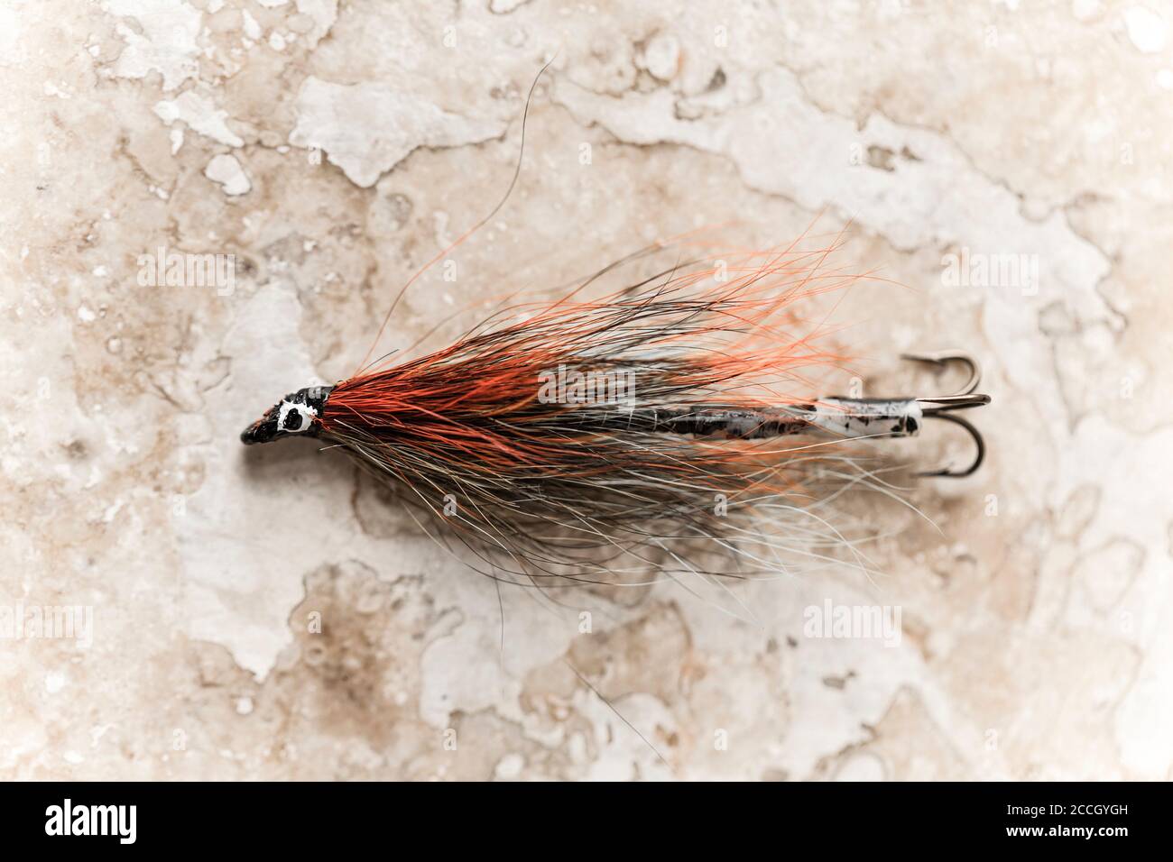 https://c8.alamy.com/comp/2CCGYGH/an-old-salmon-fly-possibly-homemade-from-a-collection-of-vintage-fishing-tackle-desaturated-colours-on-a-light-stone-background-dorset-england-uk-2CCGYGH.jpg