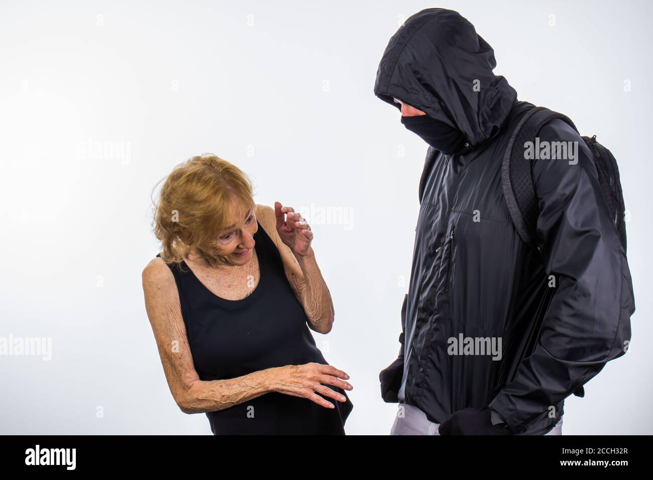 Protester With Face Mask Intimidates Small Senior Woman Stock Photo