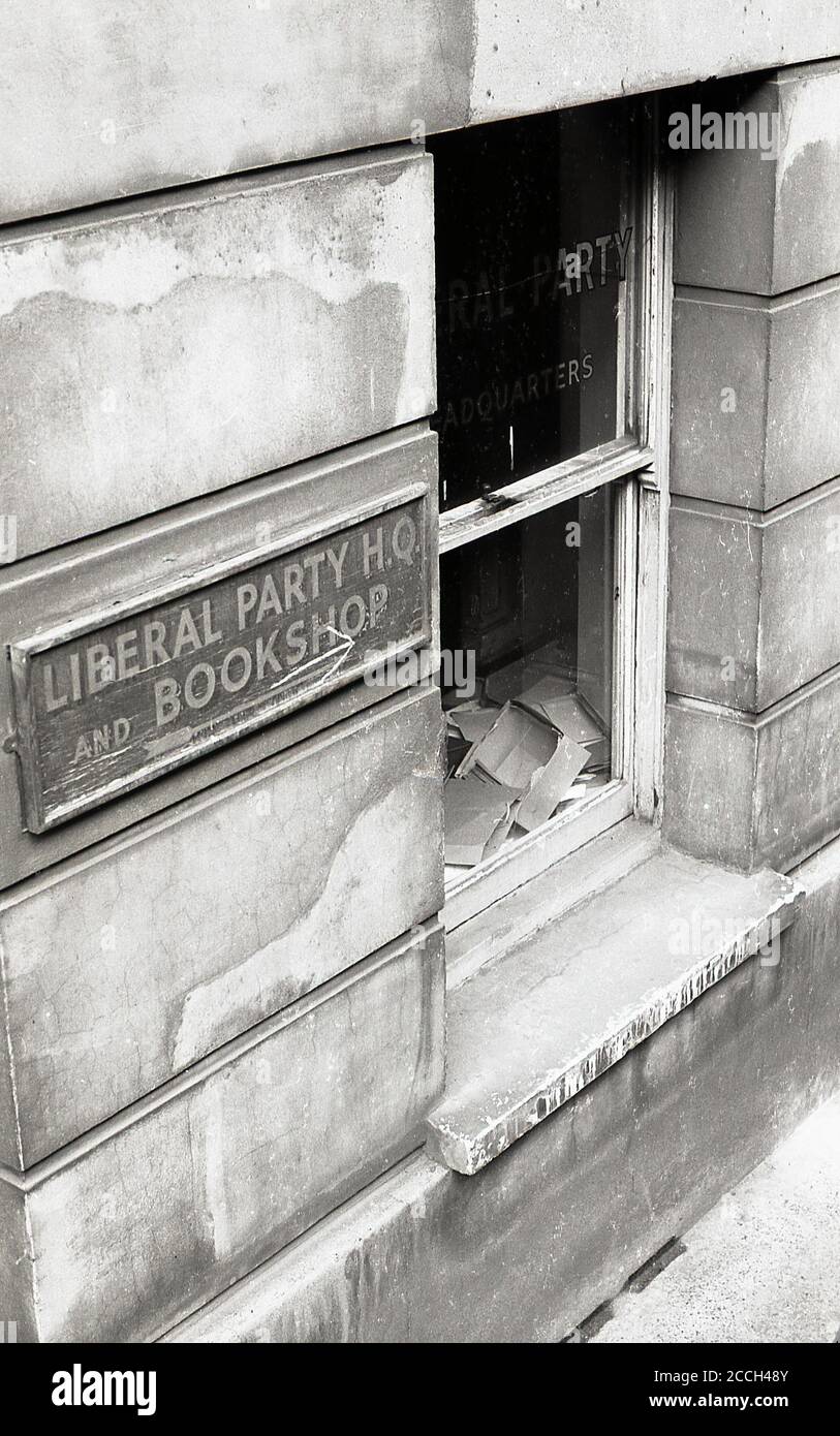 1960s, historical, Exterior view showing a soot covered sash window of the Liberal Party headquarters, Victoria, London, England, UK, with Party name stenciled into the glass. A faded wooden framed sign on the exterior of the building says 'Liberal Party HQ and Bookshop'. In the 19th and 20th centuries, the Liberal Party was one of the two major political parties in the UK, arising from a alliance of Whigs, free trade Peelites and Radicals. Stock Photo