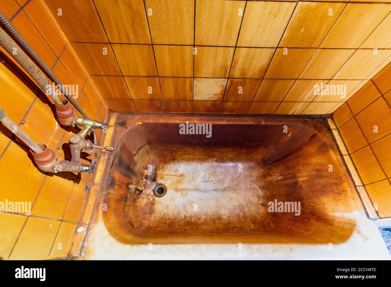 Rust stains in bathtub on wall and bath. High level Iron dissolved in a water. Ferrous Iron Stock Photo