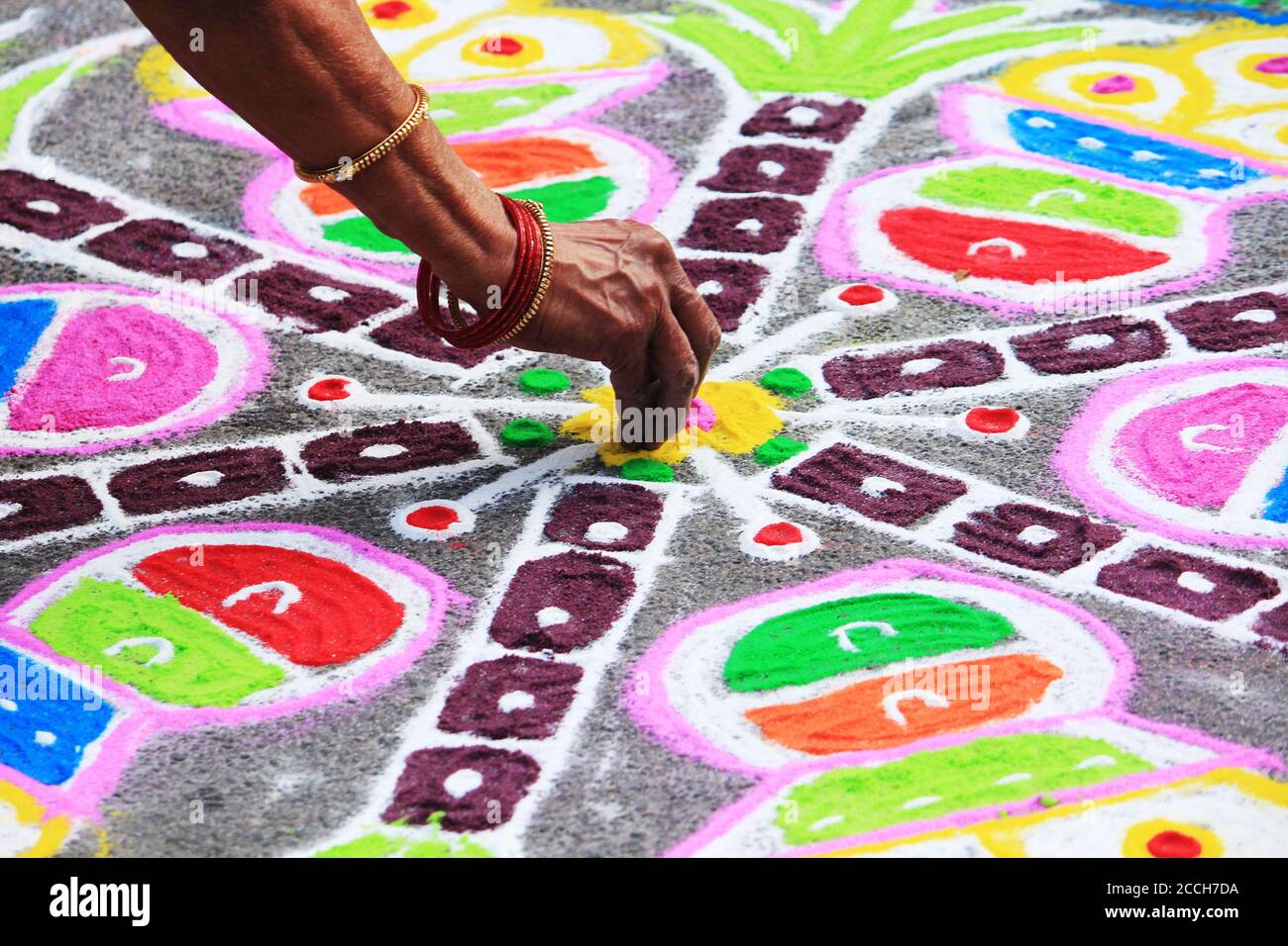 South Indian woman drawing kolam and rangoli in Mylapore Kolam contest