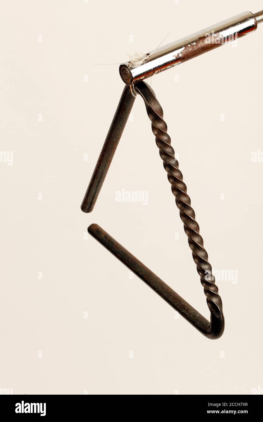 Triangle with a twisted construction to provide a serrated surface for scraping the beater along, as well as the traditional way to play it. Stock Photo