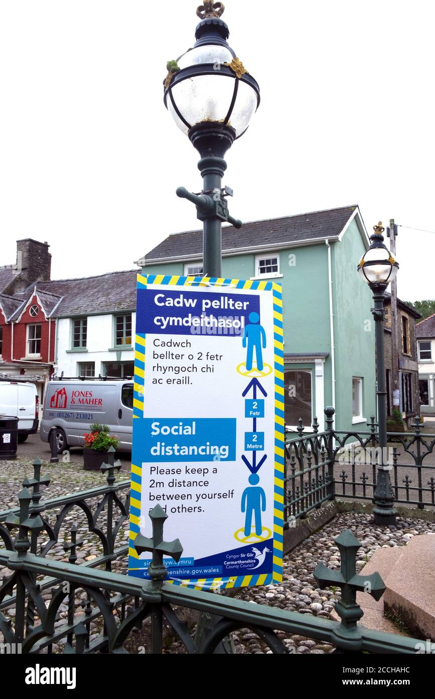 Bilingual Welsh English social distancing isign to reduce the spread of Coronavirus in town centre Llandovery Carmarthenshire Wales UK    KATHY DEWITT Stock Photo