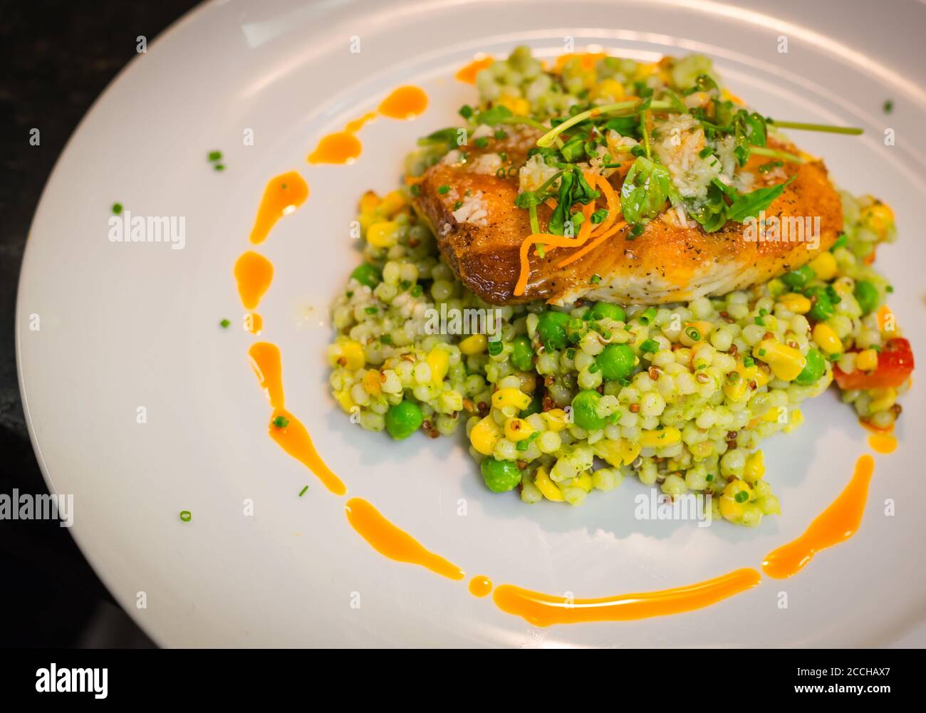 An entree of fresh fish and vegetables with sophisticated plating in a fine dining restaurant Stock Photo