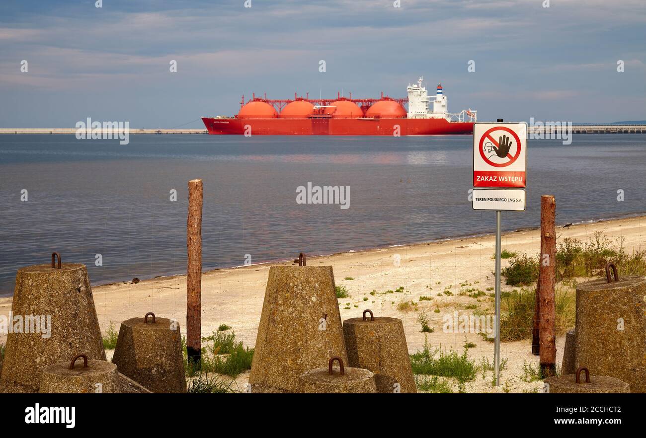 Swinoujscie, Poland - August 21, 2020: No entry sign at closed protection zone by LNG Terminal in Swinoujscie with tanker in distance at sunset. Stock Photo