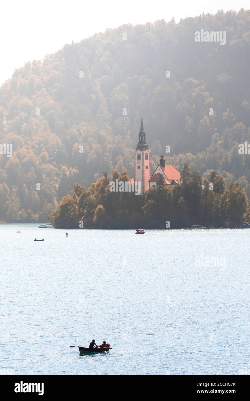 Close up of the iconic island in the middle of lake Bled at summer, with row boats gliding on the water Stock Photo