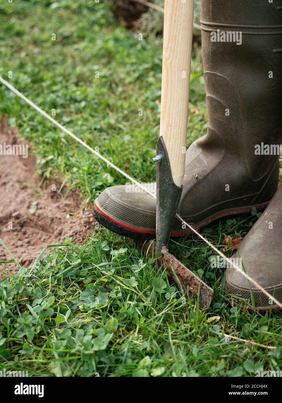 Edging a bed with a traditional hand made edging iron Stock Photo - Alamy