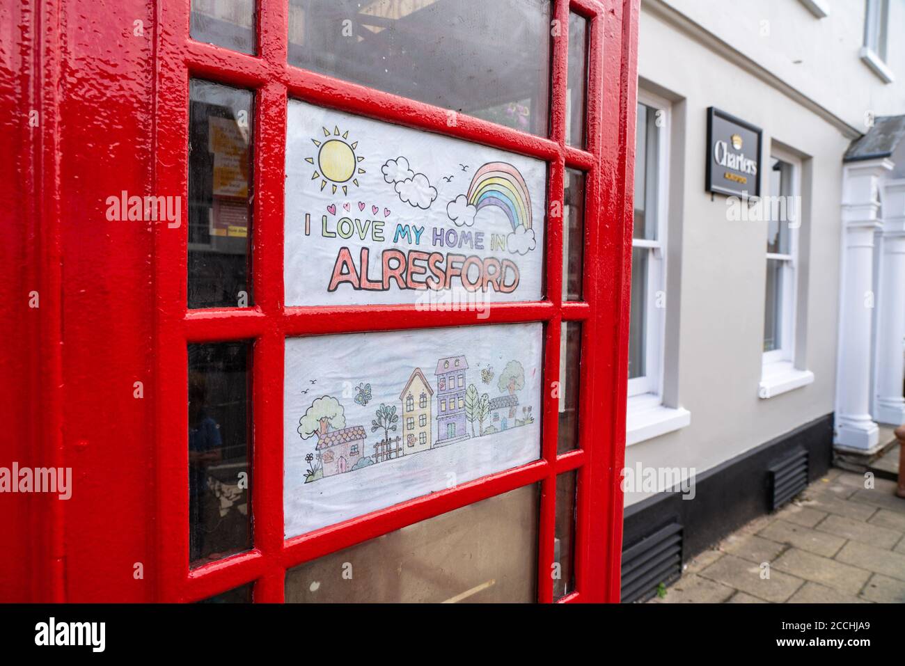 'I love my home in Alresford'. Child's drawing in telephone box with rainbow. Spreading hope during Covid 19 crisis. Stock Photo
