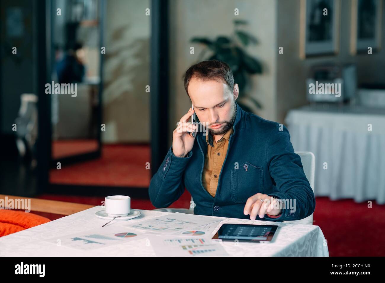 Man Working in Office and Analyzing Some Statistical Calculation Reports. Stock Photo