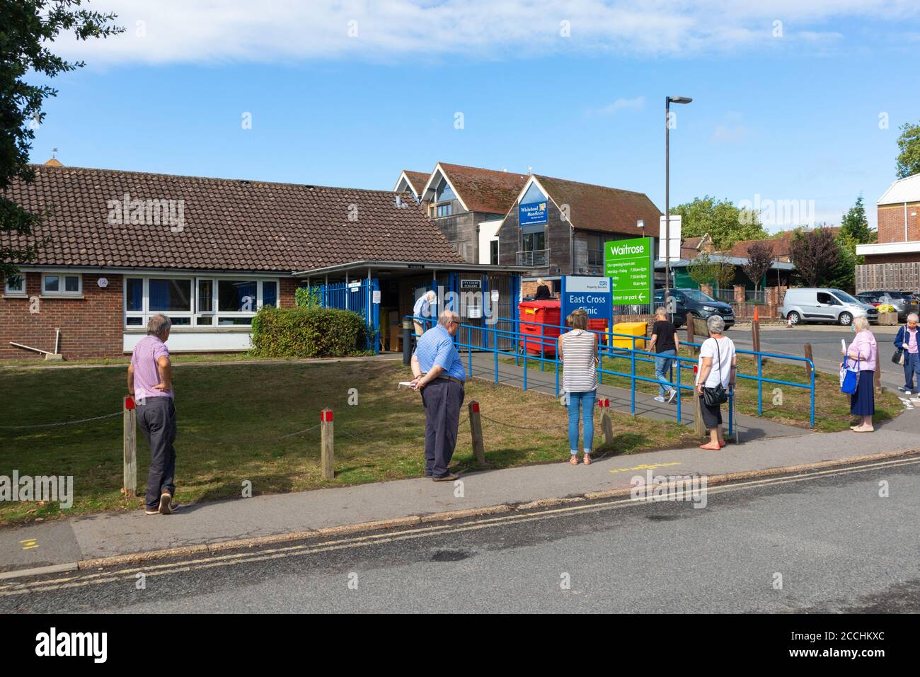 People queueing maintaning social distancing for East Cross gp clinic, tenterden, kent, uk Stock Photo