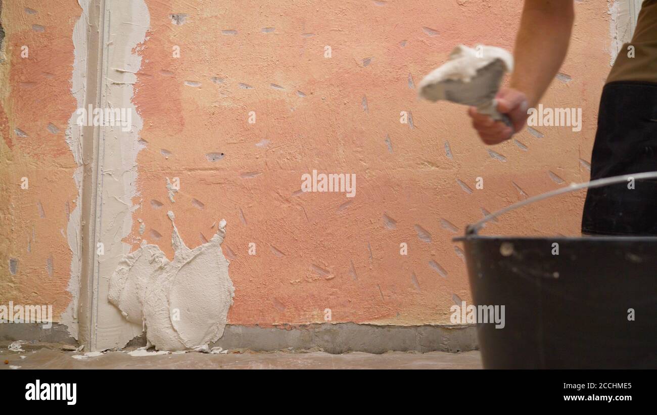 Plasterer putting plaster on wall. Putting plaster on the wall. Stucco
