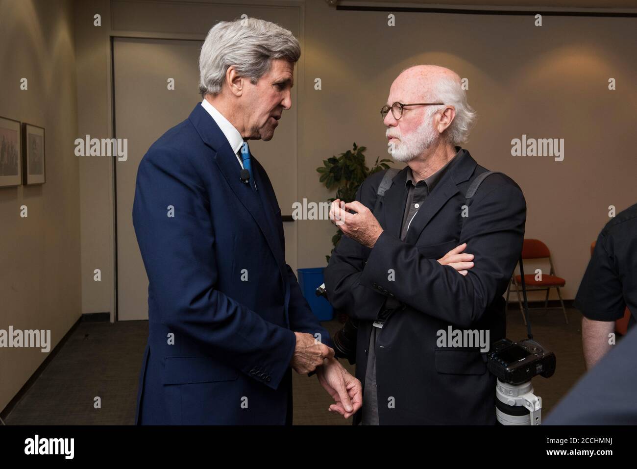 U.S. Secretary of State John Kerry, left, a Vietnam War veteran, chats with Pulitzer prize-winning photojournalist David Hume Kennerly prior to a panel discussion on the Vietnam War at the LBJ Presidential Library April 27, 2016 in Austin, Texas. Stock Photo