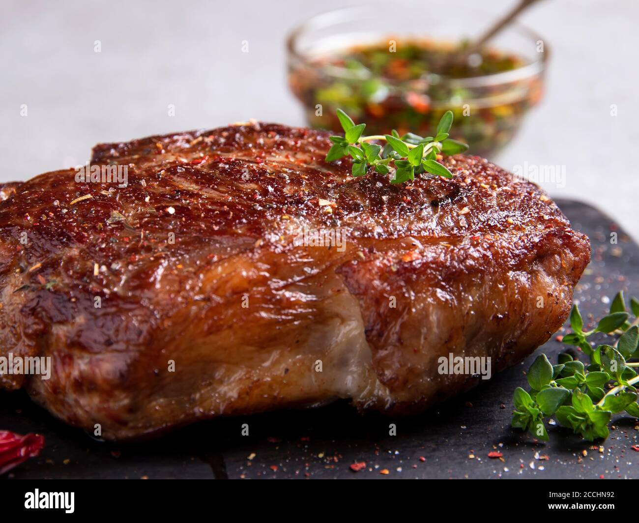 Juicy roasted beef steak with spices and thyme, close up Stock Photo