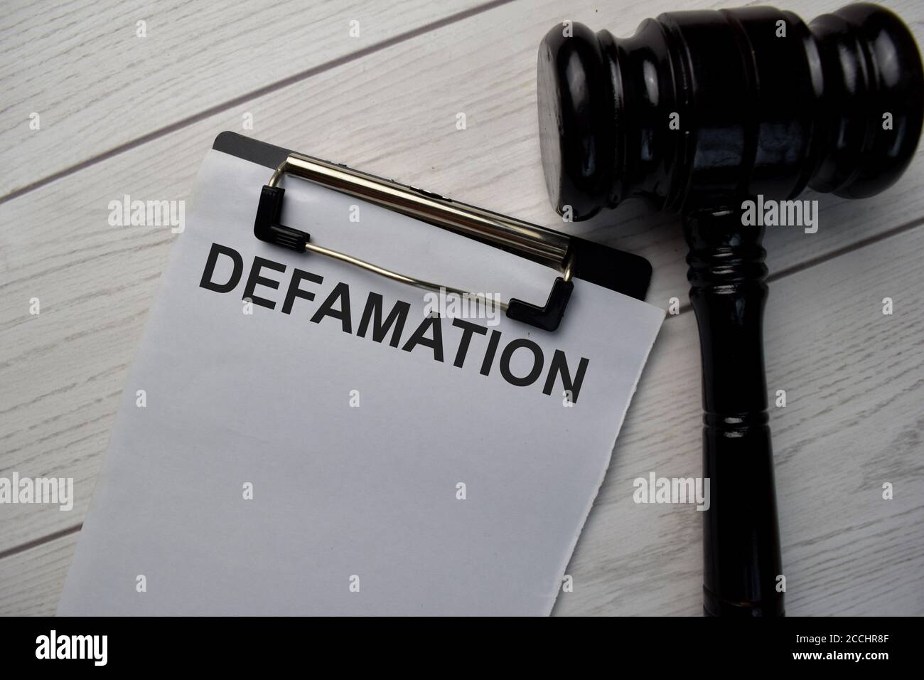 Defamation text write on a paperwork and gavel isolated on office desk. Stock Photo
