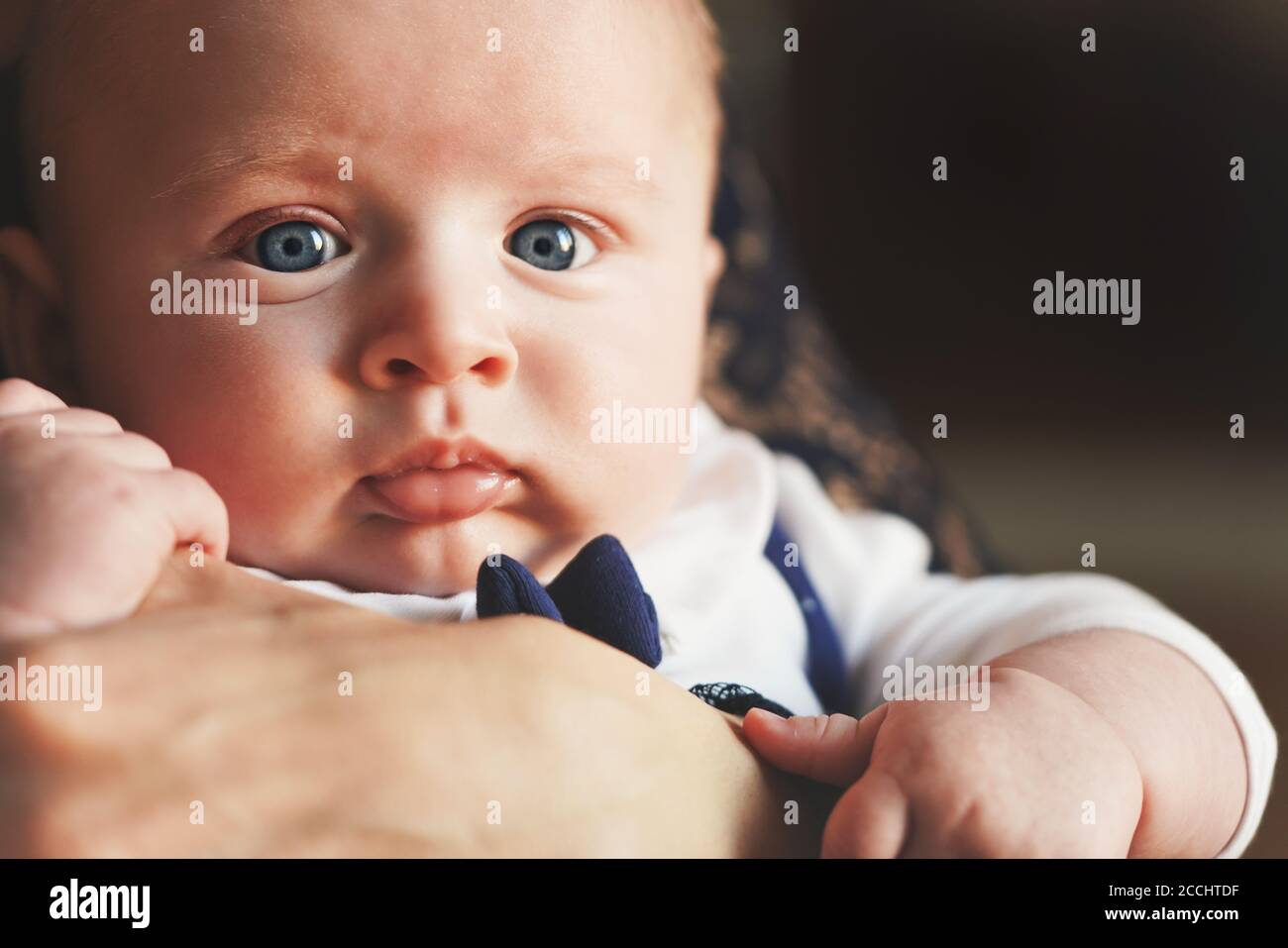 Four months old infant on her mother hands, detail on his face and blue eyes Stock Photo Alamy
