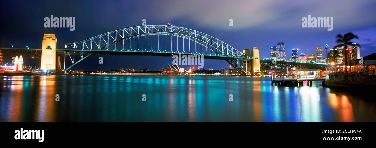 City skyline with Sydney Harbour Bridge and Lunar Park (left) on Lavender Bay at dusk Stock Photo