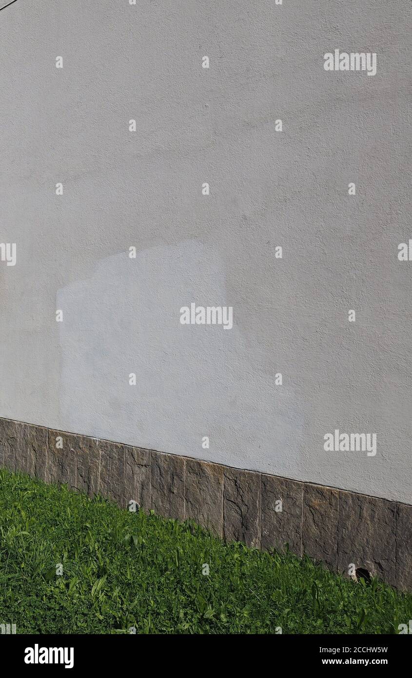 plaster wall with stone tiles and grass useful as a background Stock ...
