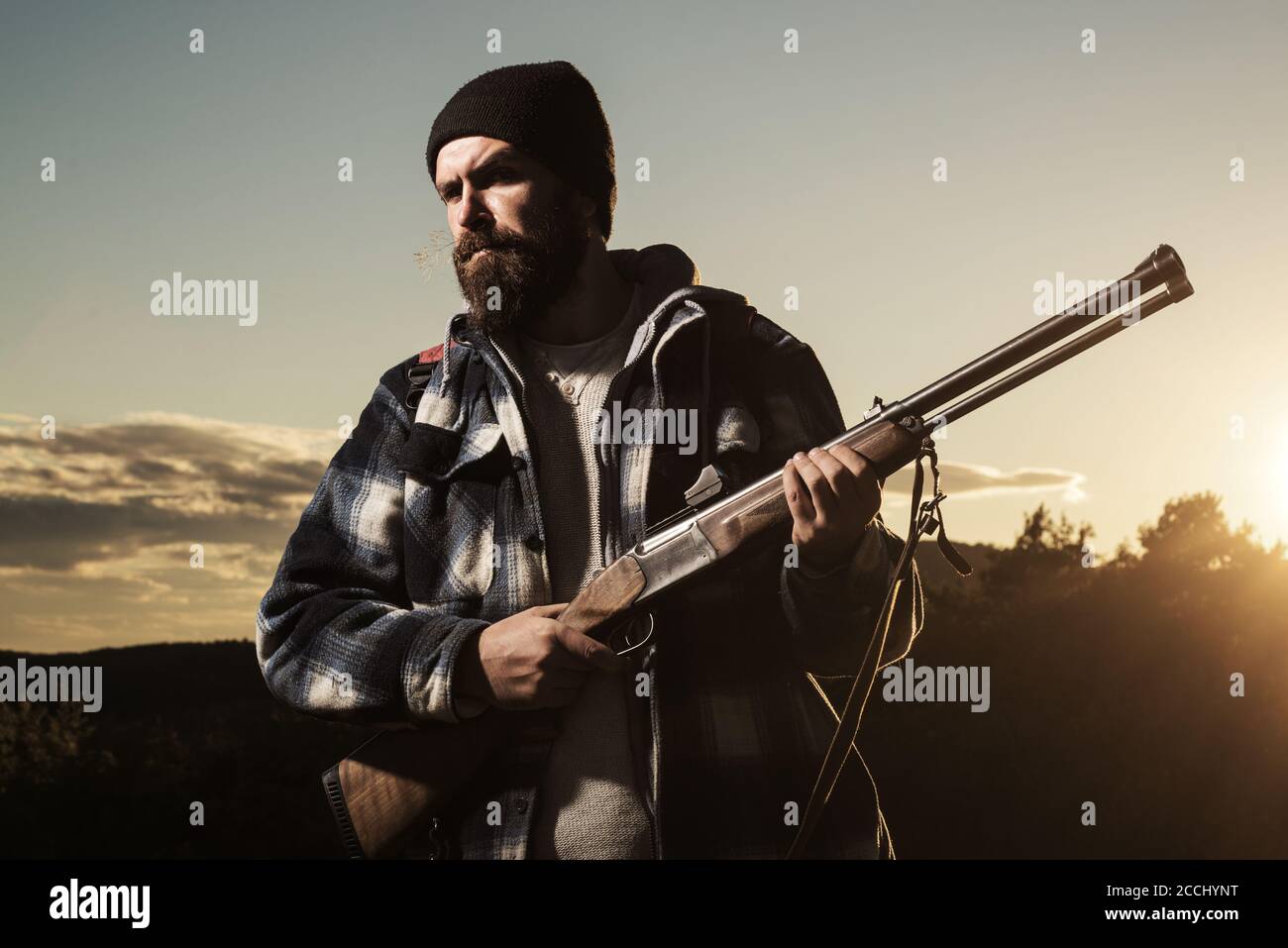 Hunter with a hunting gun in the autumn forest. Rifle hunter in Sunset ...
