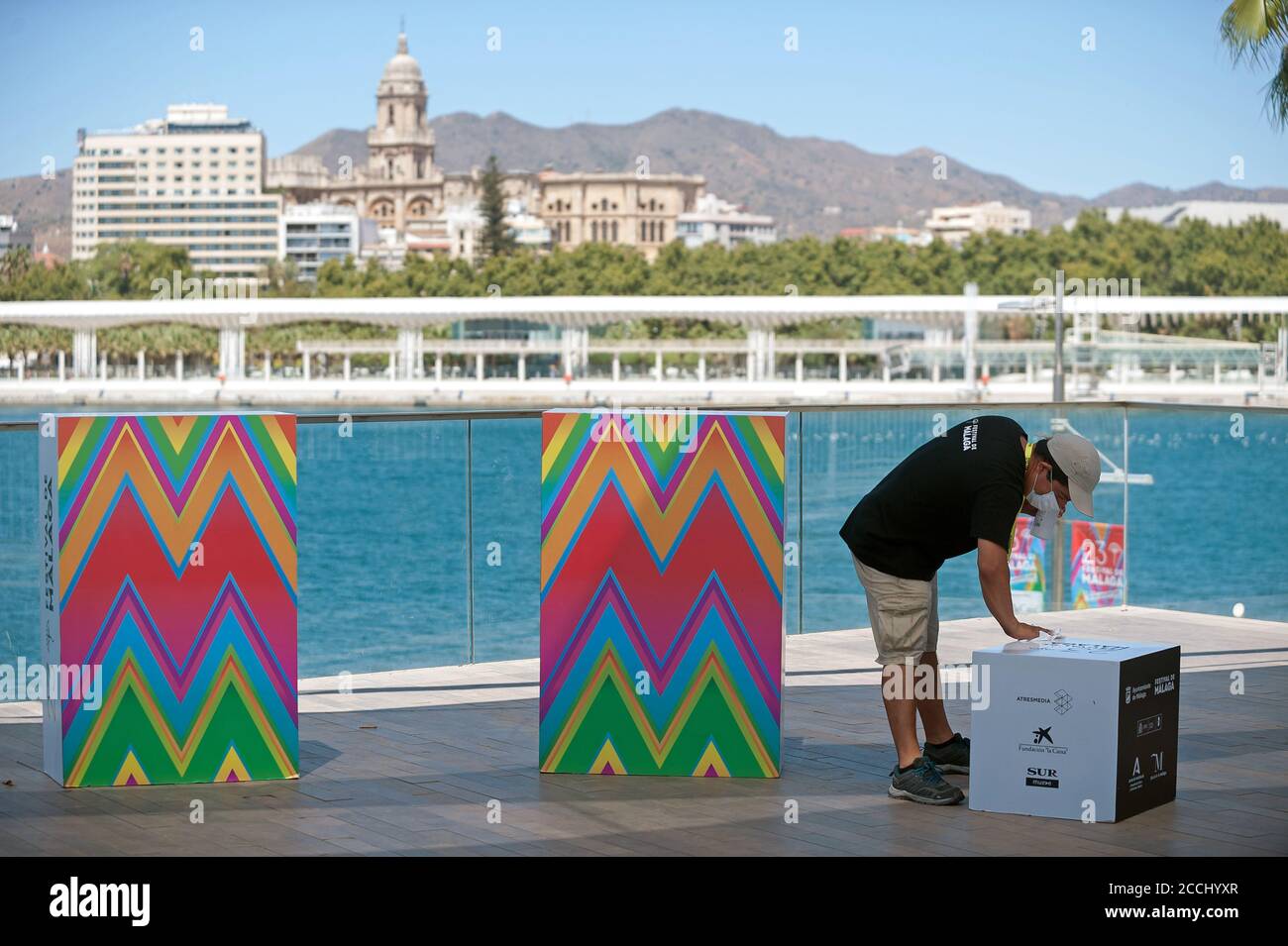 Malaga, Spain. 22nd Aug, 2020. An employee is seen disinfecting a box before the film 'Hasta el cielo' photocall at Muelle Uno.The 23rd edition of the Spanish Malaga Film Festival is the first great cinematographic event in Spain after it was postponed due to coronavirus pandemic last month of March. The organization has introduced measures to prevent the spread for coronavirus and to guarantee a secure event. The festival will be held from 21 to 30 August. Credit: SOPA Images Limited/Alamy Live News Stock Photo