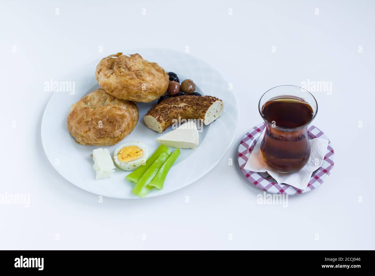 Traditional Turkish Savory Pastry 'Boyoz' in plate with sesame bagel,egg,olives and sliced tomato,breakfast plate in white with tea Stock Photo