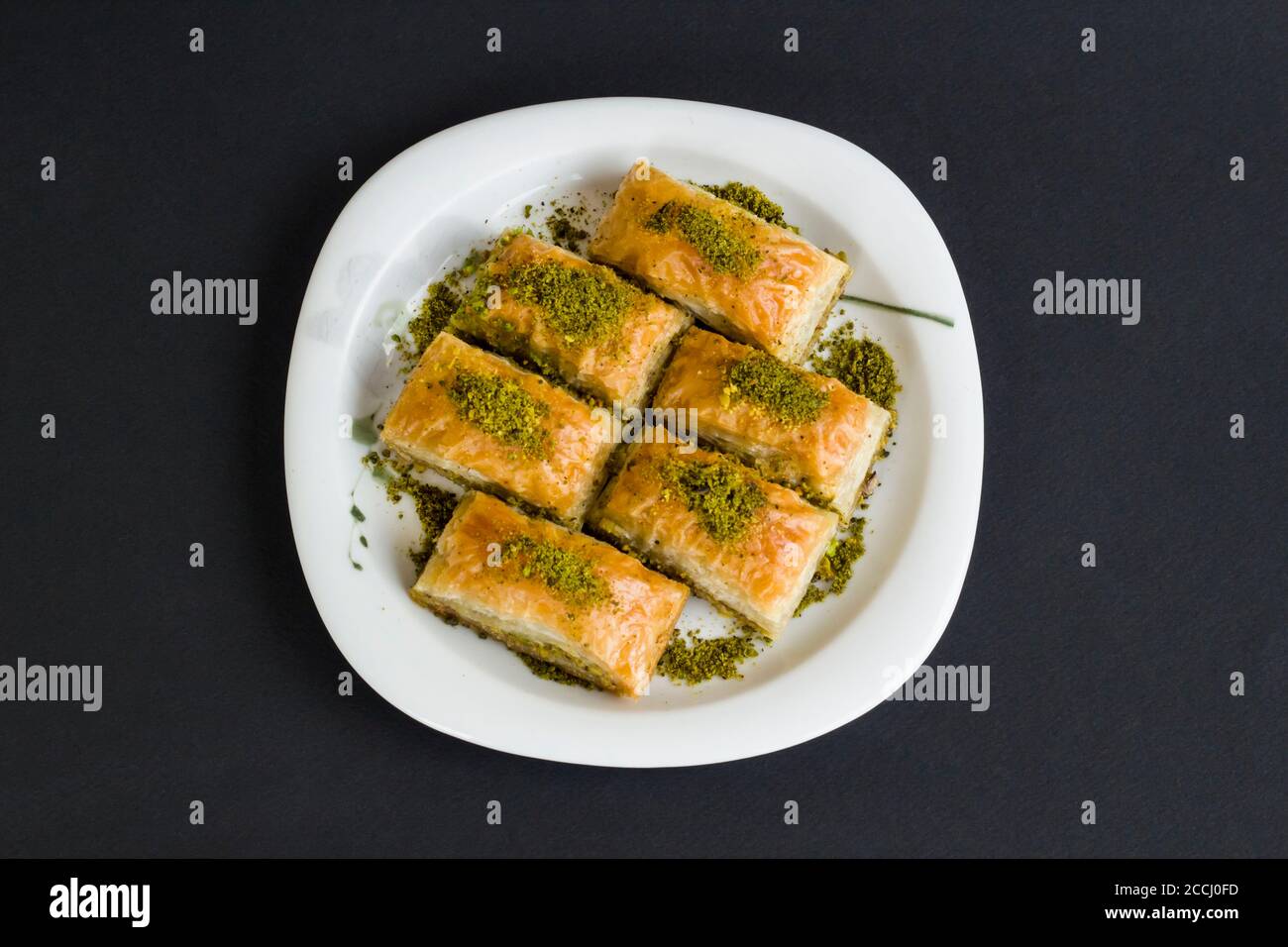 Traditional Turkish Pastry Dessert,Pistachio Baklava in plate at black surface with copy space. Stock Photo