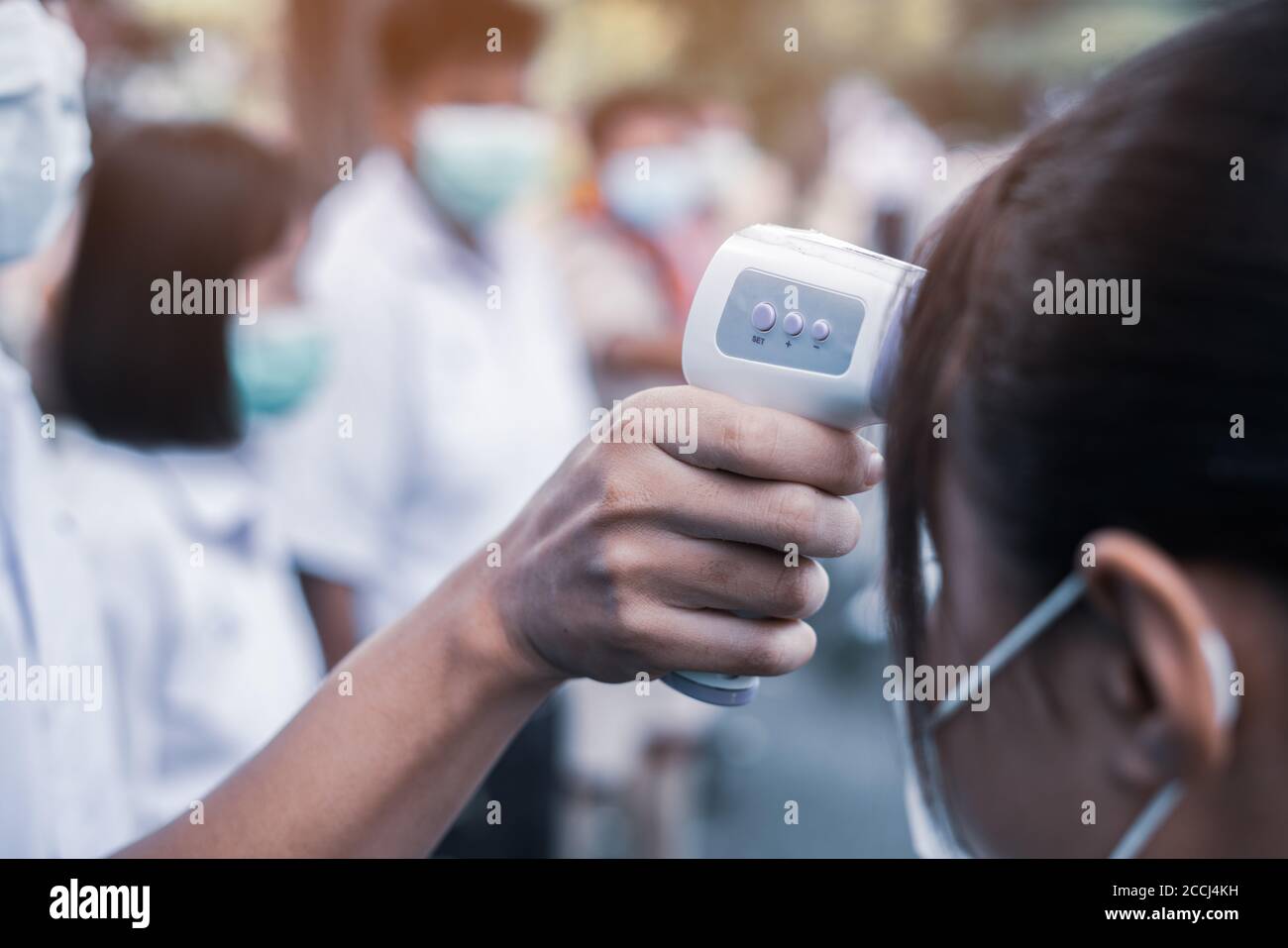 Hand holding Infrared thermometer gun forehead temperature test to ...