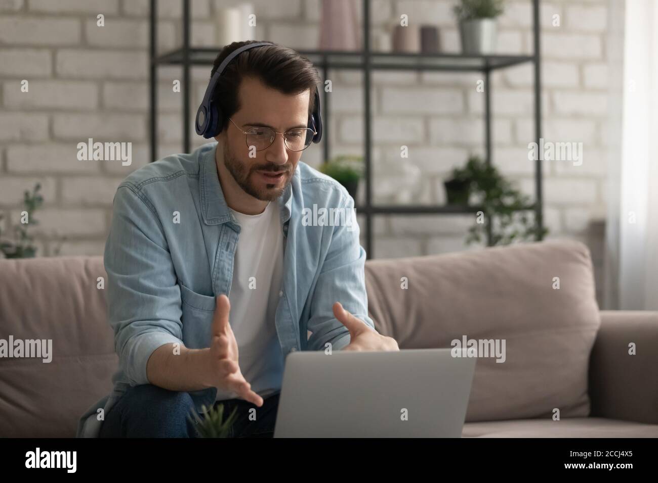 Caucasian man in headphones talk on video call on laptop Stock Photo ...