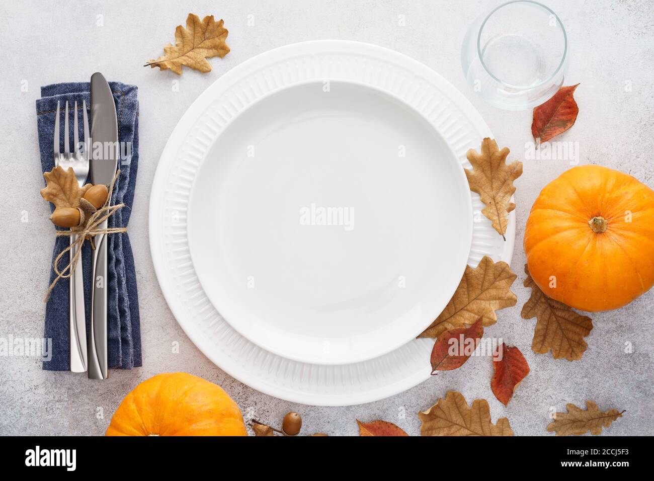 Fall season table setting with pumpkins, leaves and cutlery - fork and ...