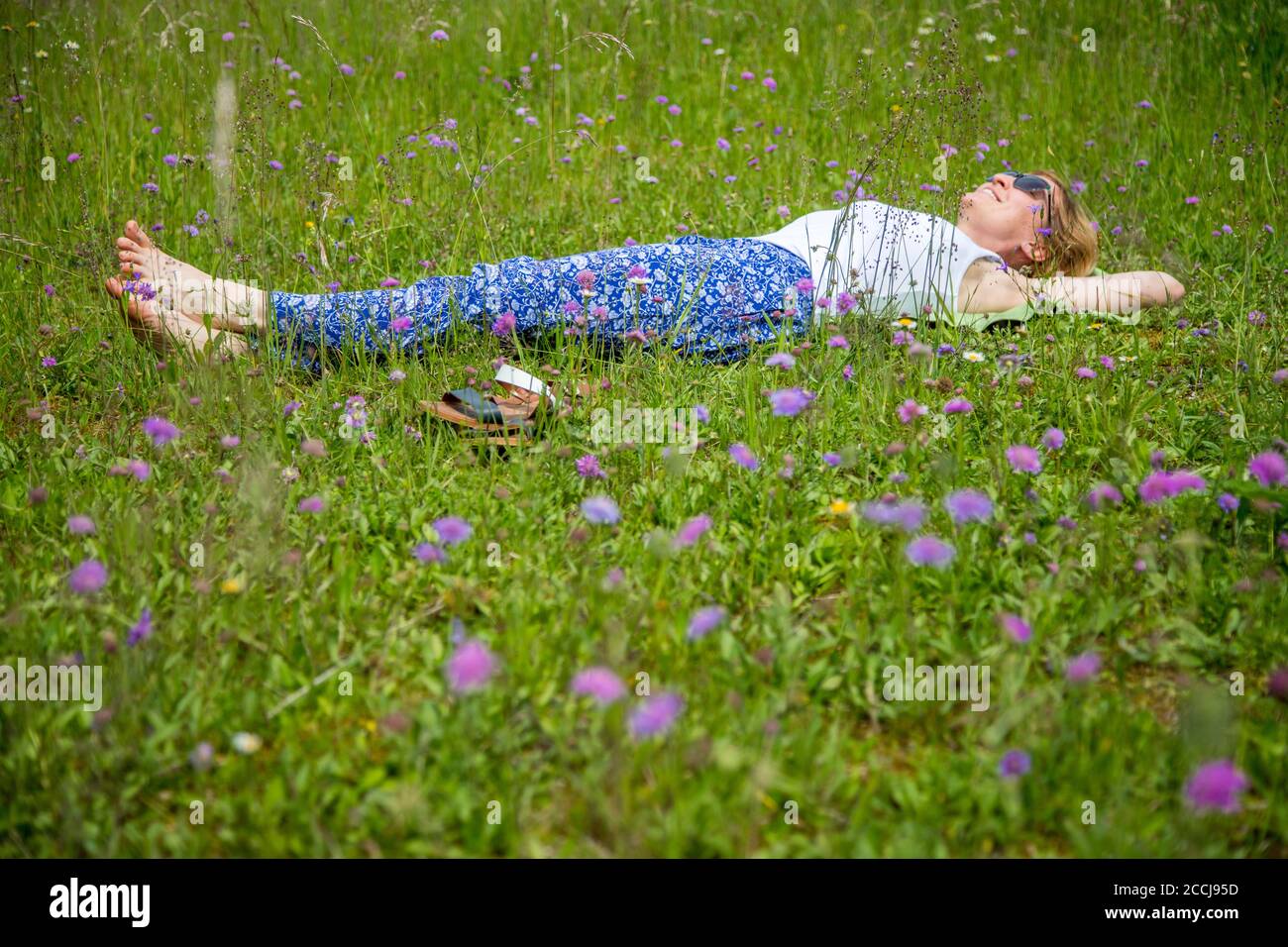 Young girl in park is lying in the grass, enjoying the day Stock Photo ...