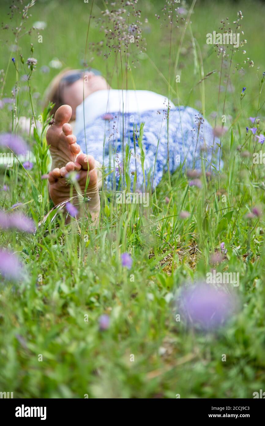 Young girl in park is lying in the grass, enjoying the day Stock Photo ...