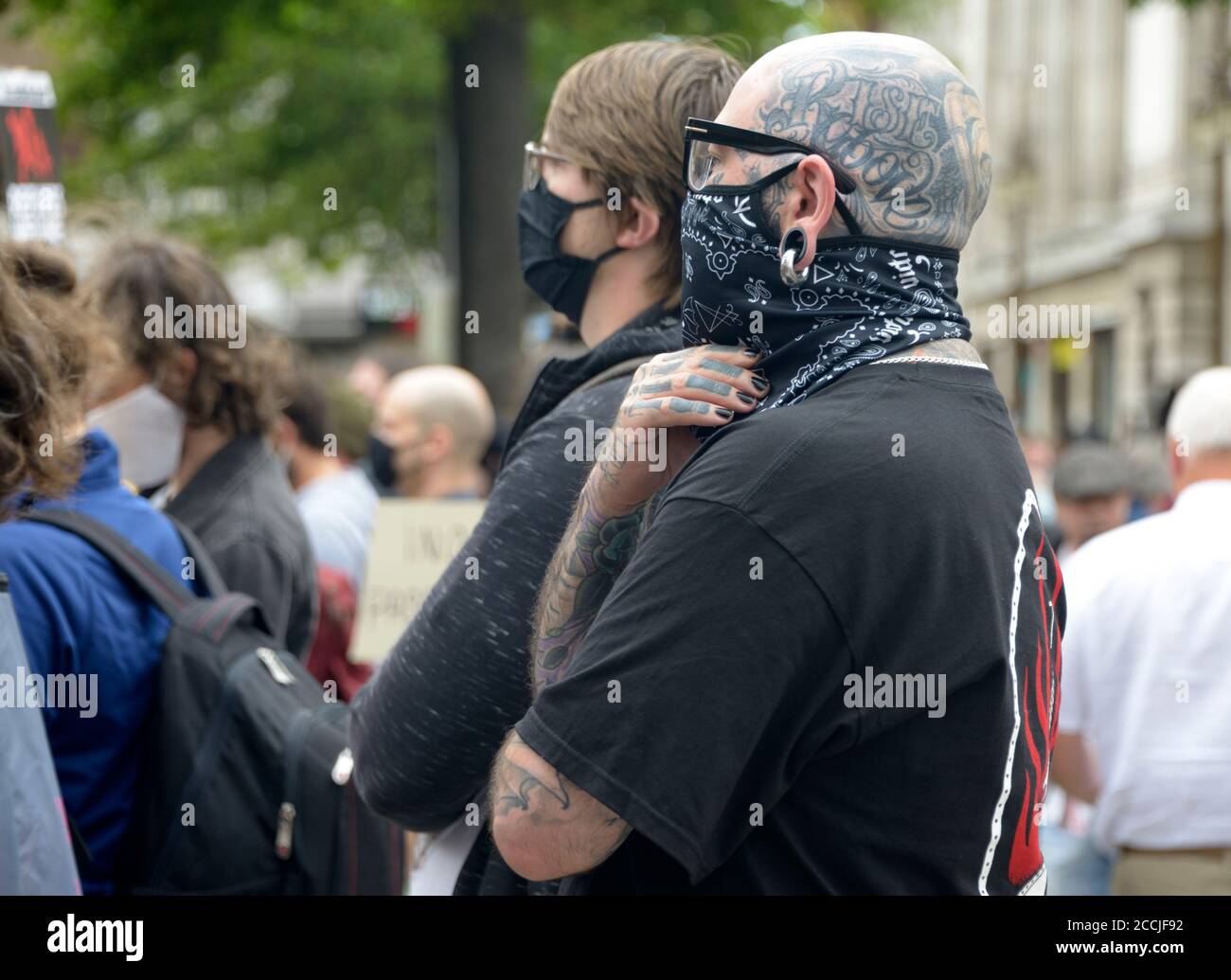 Atheist with tattooed head with face mask, at protest Stock Photo