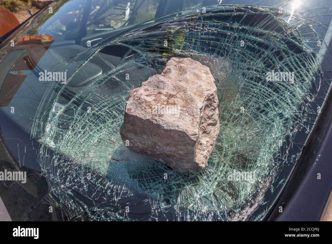 broken car windshield with a huge stone Stock Photo