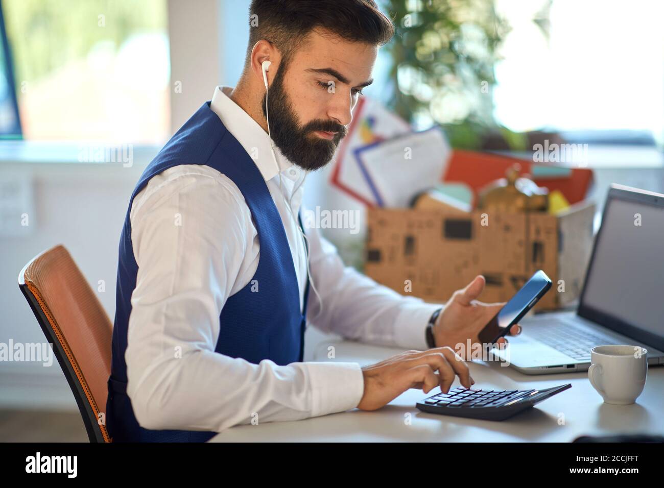 Young accountant working on calculator in the office Stock Photo