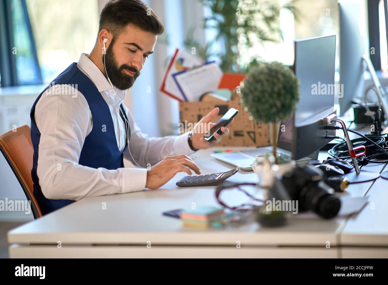 Young accountant working with calculator in the office Stock Photo