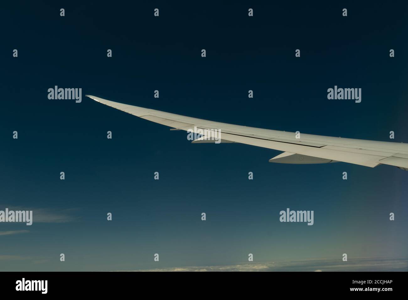 Wing of airplane flying above the clouds in the sky Stock Photo - Alamy