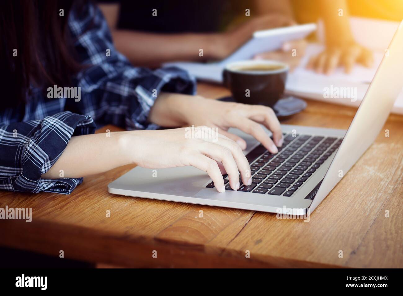 Teamwork,brainstorming concept.Young Asian creative managers team working with new startup project in modern office. Contemporary notebook on wood tab Stock Photo